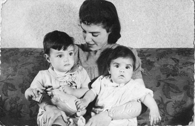 878184 Groepsportret van moeder Sophia Klein-Jansen, met haar kinderen Joop en Wil op schoot, in de huiskamer van de ...